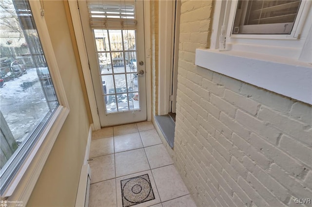 entryway featuring light tile patterned flooring and brick wall