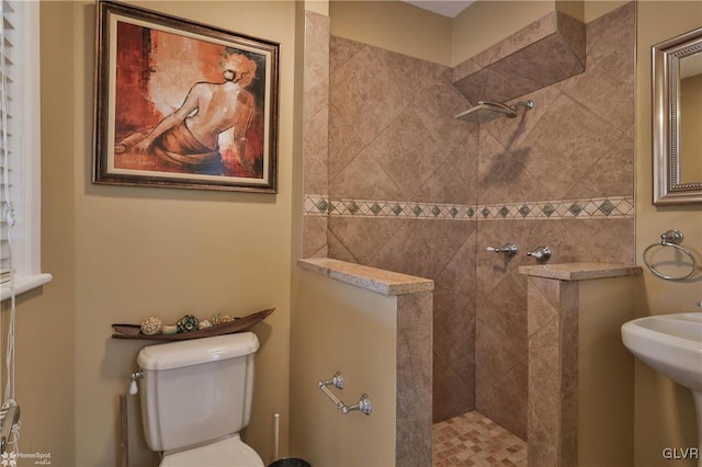 bathroom with toilet and tiled shower