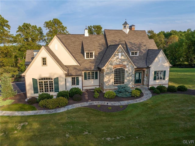 french provincial home featuring a front lawn