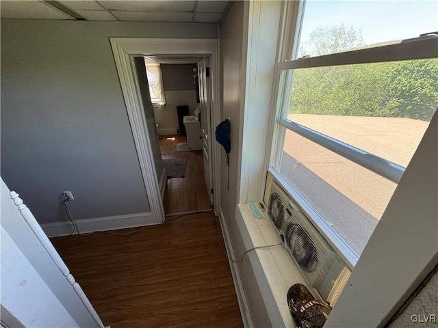 corridor featuring a paneled ceiling, ac unit, and wood-type flooring