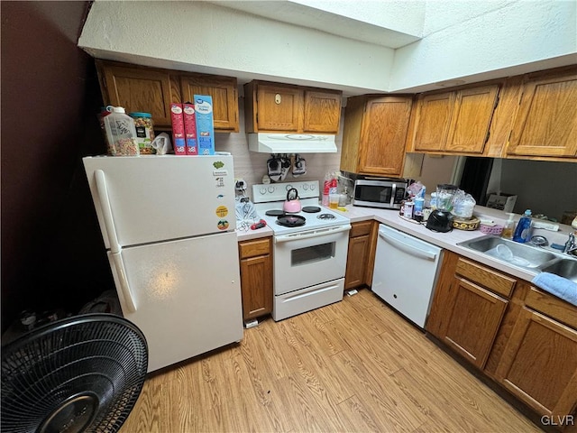 kitchen with light hardwood / wood-style floors, white appliances, and sink