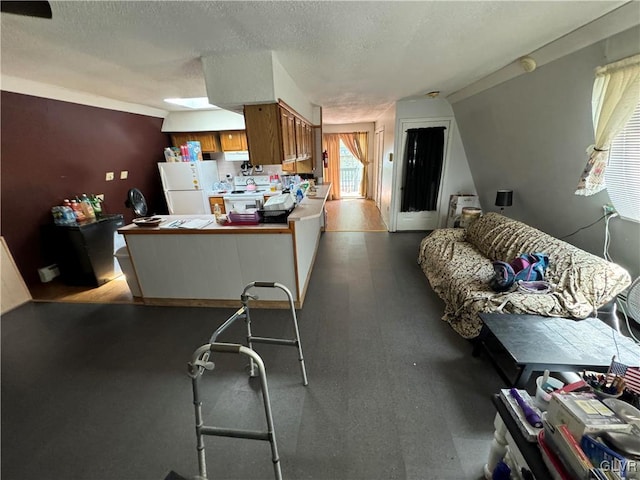 kitchen featuring a breakfast bar, a textured ceiling, and white refrigerator