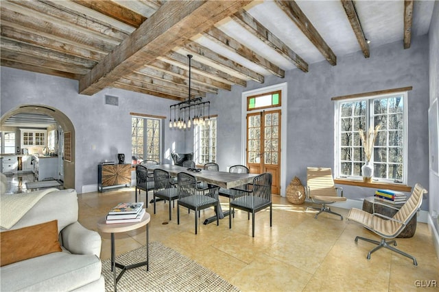 dining room with beamed ceiling and a notable chandelier