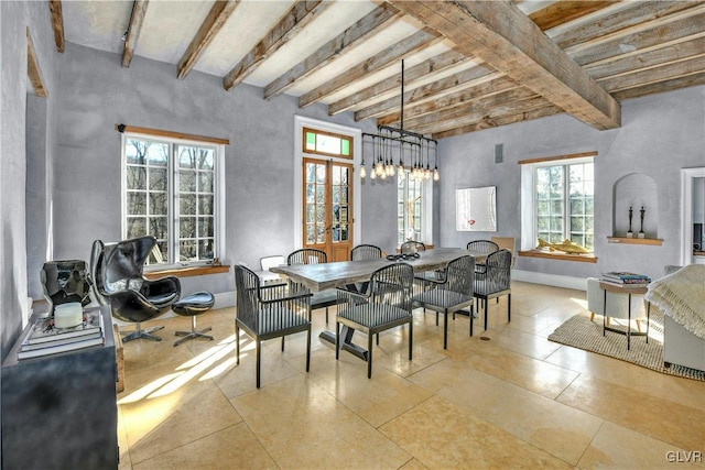 dining space with plenty of natural light, beam ceiling, and a chandelier