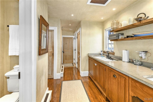 bathroom with hardwood / wood-style floors, vanity, and toilet