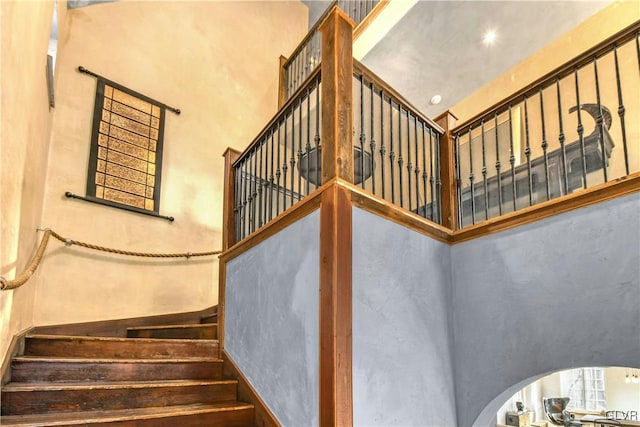 staircase featuring a towering ceiling