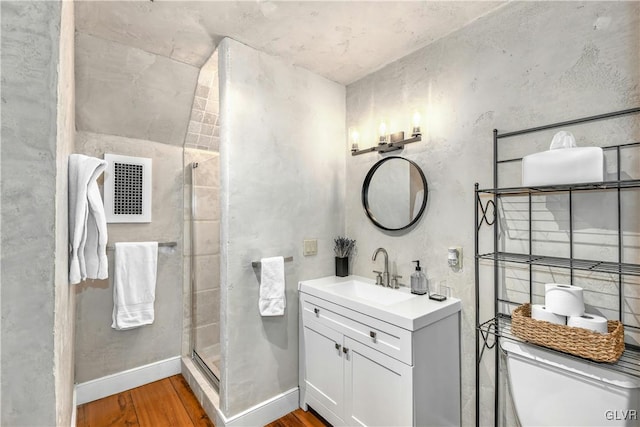 bathroom with hardwood / wood-style flooring, vanity, toilet, and an enclosed shower