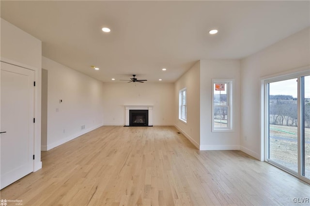 unfurnished living room with light hardwood / wood-style flooring, ceiling fan, and a healthy amount of sunlight