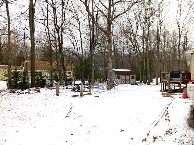 yard layered in snow with a storage shed