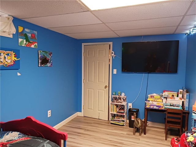 bedroom with a drop ceiling and hardwood / wood-style floors