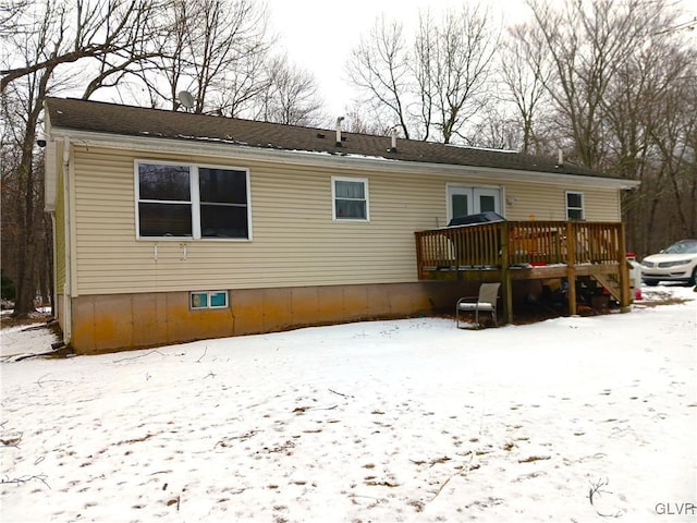 snow covered property featuring a deck