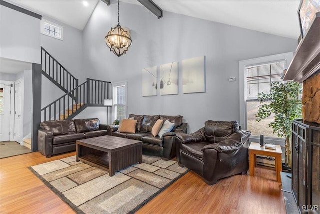 living room with hardwood / wood-style floors, beamed ceiling, high vaulted ceiling, and an inviting chandelier