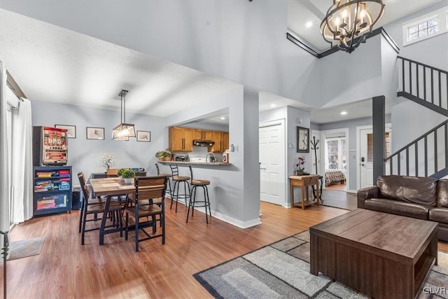 dining area with light hardwood / wood-style flooring, a wealth of natural light, and a notable chandelier