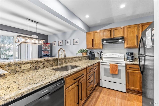 kitchen featuring black appliances, sink, light hardwood / wood-style flooring, light stone counters, and kitchen peninsula