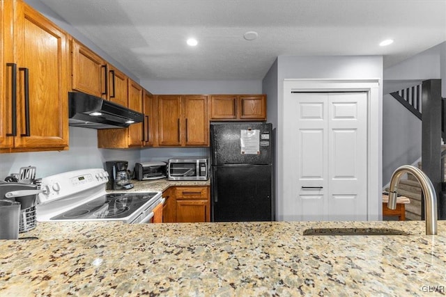 kitchen with black refrigerator, light stone counters, a textured ceiling, sink, and white electric stove