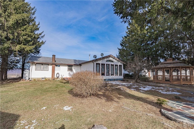 view of front facade with a front lawn, a gazebo, and a sunroom