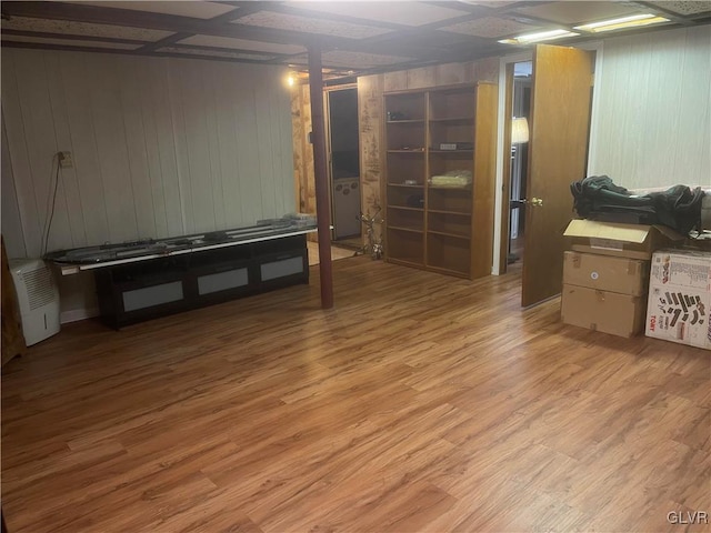 basement featuring light hardwood / wood-style flooring and wooden walls