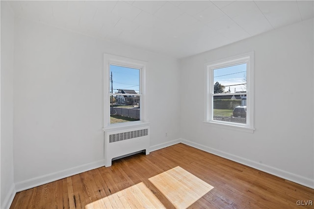 unfurnished room with radiator and light hardwood / wood-style floors