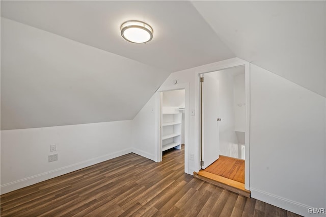 bonus room with dark hardwood / wood-style floors and vaulted ceiling