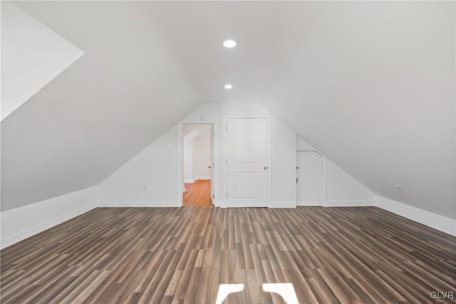 additional living space featuring lofted ceiling and dark wood-type flooring