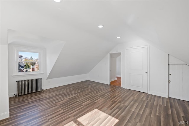 additional living space featuring radiator, dark wood-type flooring, and lofted ceiling