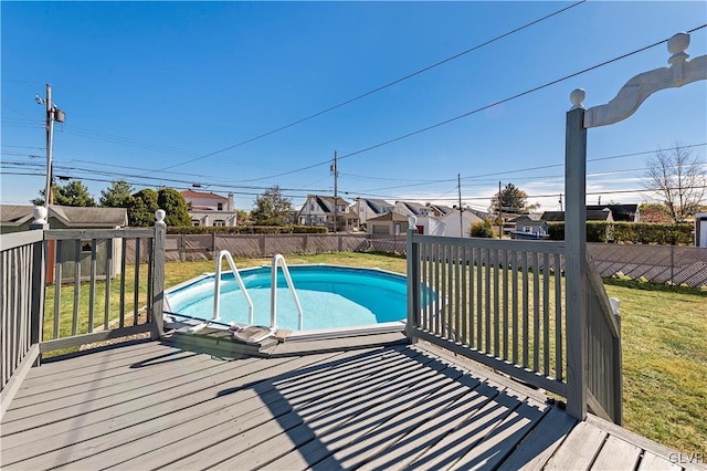 view of pool featuring a lawn and a deck