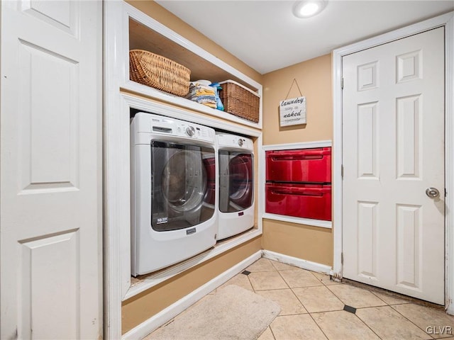 washroom with light tile patterned flooring and washer and dryer