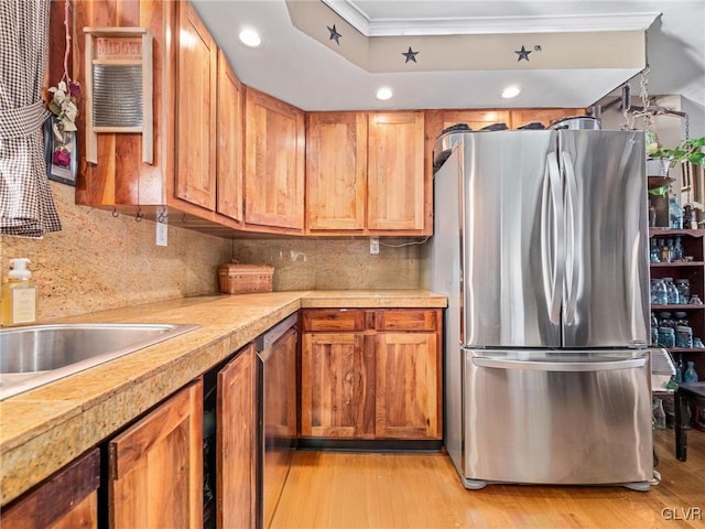 kitchen featuring sink, tasteful backsplash, light wood-type flooring, appliances with stainless steel finishes, and ornamental molding