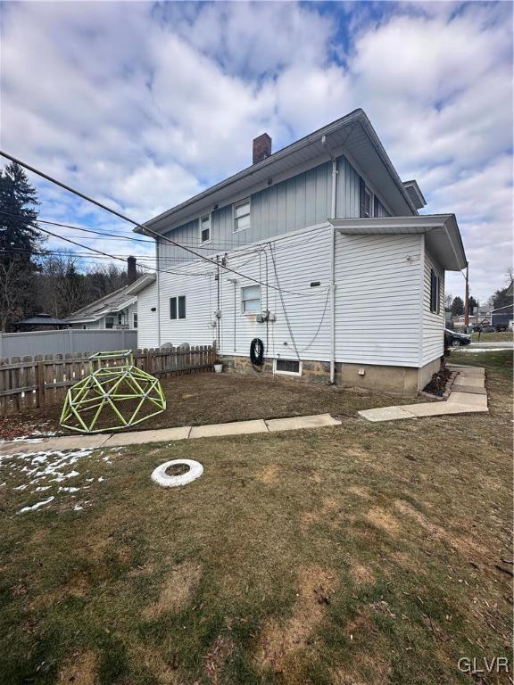 back of house featuring a lawn