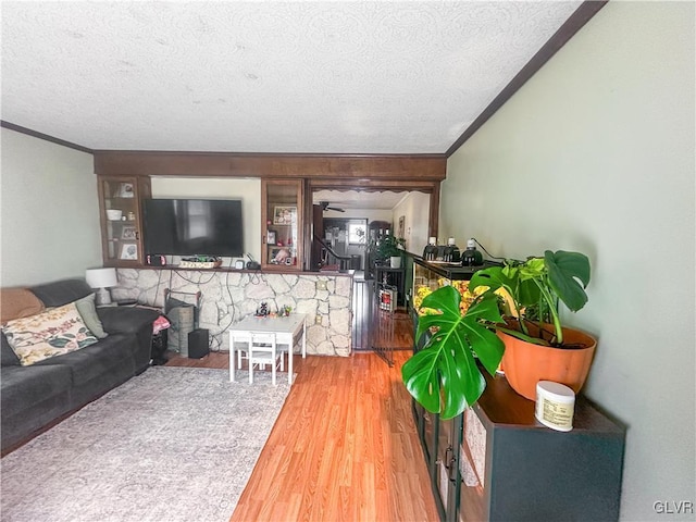 living room featuring hardwood / wood-style floors, ceiling fan, and a textured ceiling