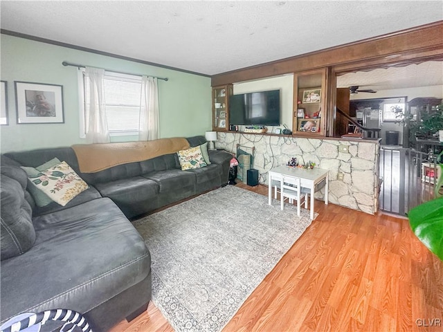 living room featuring crown molding, hardwood / wood-style floors, ceiling fan, and a textured ceiling