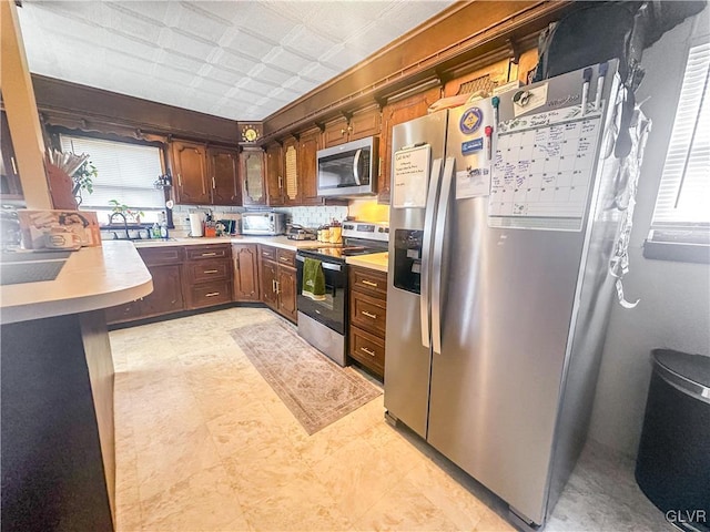 kitchen with backsplash, sink, and stainless steel appliances