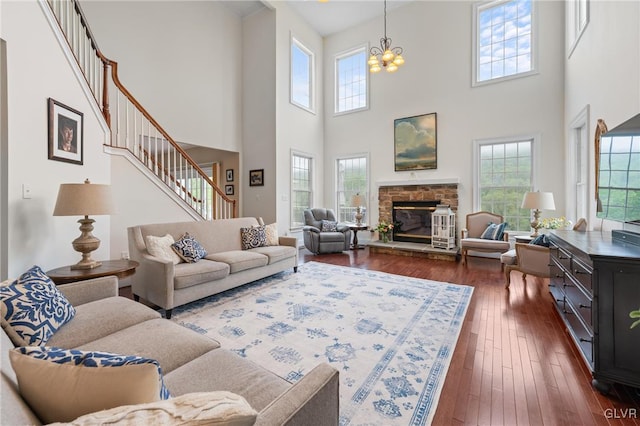 living room featuring a fireplace, plenty of natural light, and a towering ceiling