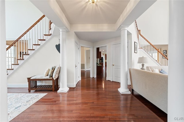 foyer featuring decorative columns and dark wood-type flooring