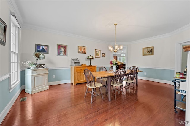 dining area with a chandelier, hardwood / wood-style flooring, and ornamental molding