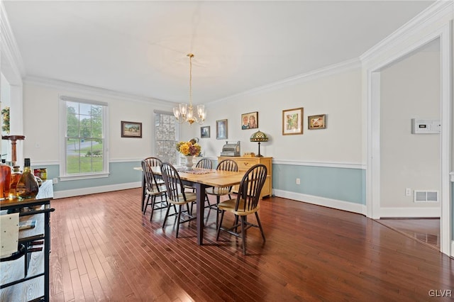 dining space featuring a notable chandelier, dark hardwood / wood-style floors, and ornamental molding