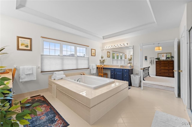 bathroom with a raised ceiling, vanity, tile patterned floors, and tiled tub