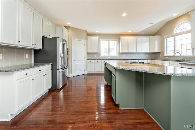 kitchen with a healthy amount of sunlight, white cabinetry, light stone counters, and dark hardwood / wood-style floors