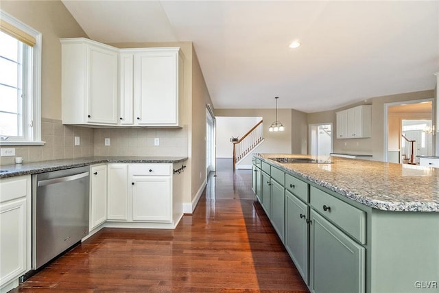 kitchen with white cabinets, dishwasher, a kitchen island with sink, and tasteful backsplash