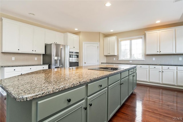 kitchen featuring a center island, white cabinetry, stainless steel appliances, and green cabinetry