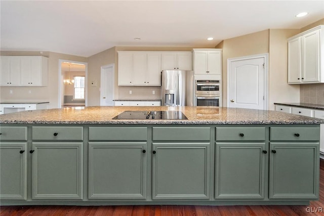 kitchen with appliances with stainless steel finishes, a center island, white cabinetry, and green cabinetry