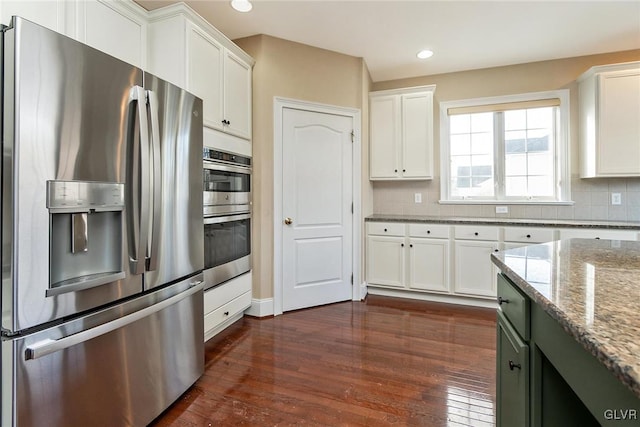 kitchen featuring tasteful backsplash, white cabinetry, light stone counters, and appliances with stainless steel finishes