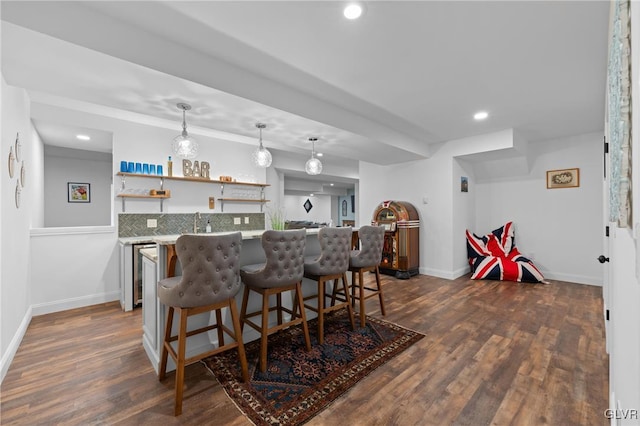 bar with dark hardwood / wood-style floors and hanging light fixtures