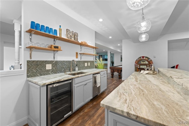 kitchen with light stone countertops, sink, beverage cooler, decorative light fixtures, and pool table