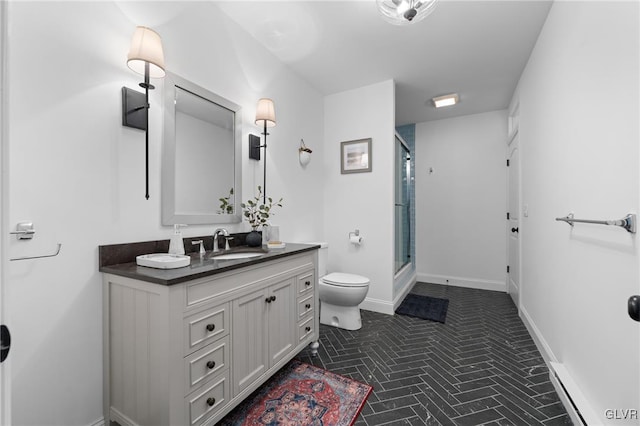 bathroom with vanity, toilet, and a shower with door