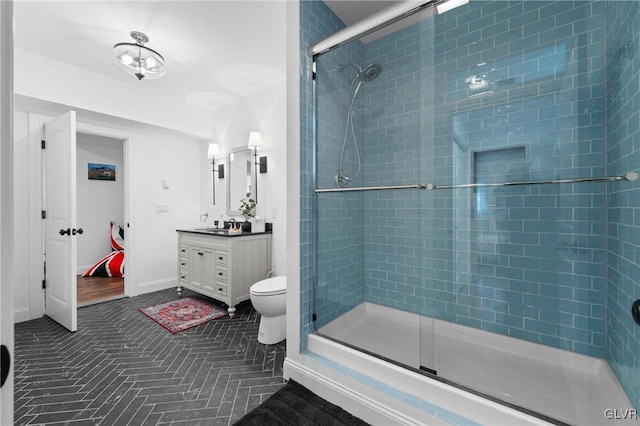 bathroom featuring vanity, toilet, and a shower with door