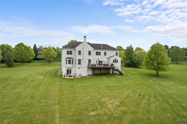 rear view of property featuring a deck and a lawn