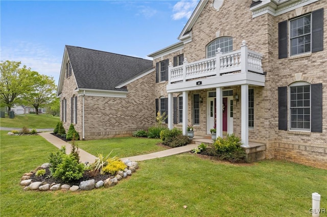 view of front facade featuring a balcony and a front lawn