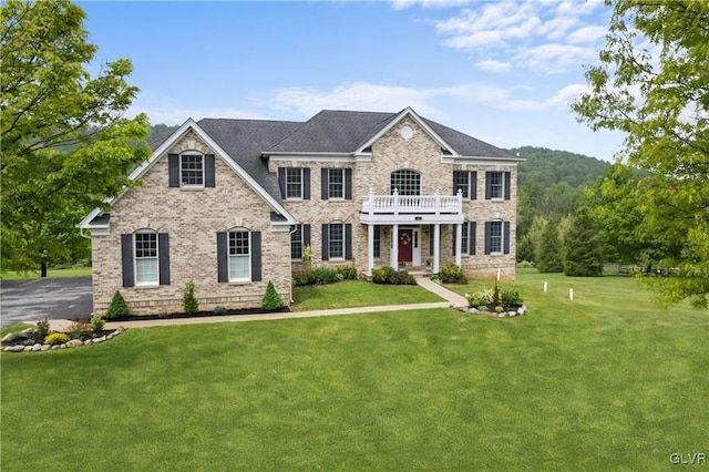 view of front of property with a balcony and a front yard