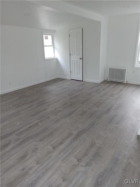 unfurnished room with light hardwood / wood-style flooring and radiator